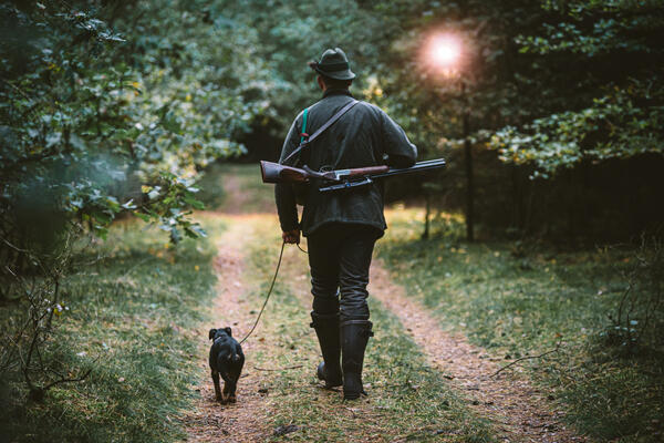 Bild vergrößern: Hunter,In,The,Woods,With,His,Dog